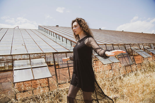 woman in black long sleeve dress standing on brown grass field during daytime