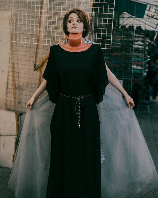 woman in black dress standing on stairs