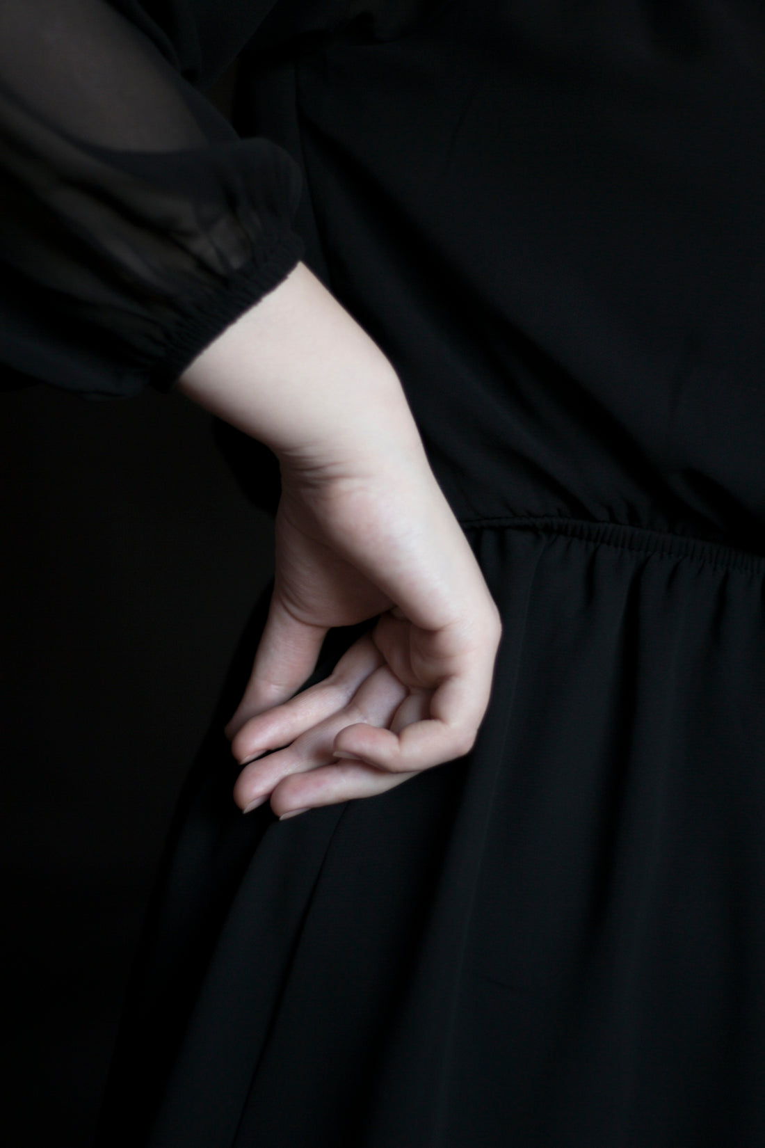 A hand rests on a black dress