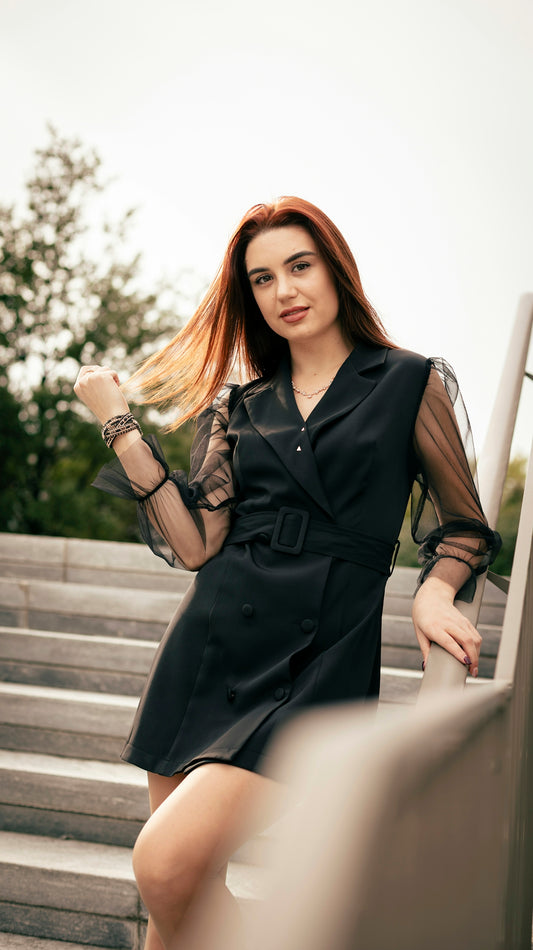 A woman in a black dress standing on some steps